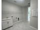 Bright laundry room featuring a sink, white cabinets, and a wire shelf for storage at 5385 Park Guell St, St Cloud, FL 34771