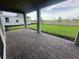 Covered patio with brick pavers overlooking a well-maintained lawn and providing a comfortable outdoor space at 5385 Park Guell St, St Cloud, FL 34771