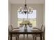 Elegant dining room featuring a table set for six, a stylish chandelier, and a large window offering natural light at 7916 Waterfield Ave, Orlando, FL 32832