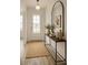 Bright entryway featuring a front door, a stylish console table with decor, and an arched mirror creating an inviting space at 7916 Waterfield Ave, Orlando, FL 32832