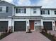 Charming two-story townhome featuring a well-manicured brick entryway and a convenient attached garage at 5086 Rain Shadow Dr, St Cloud, FL 34772