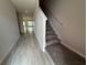 Inviting hallway with wood-look tile flooring and a staircase at 5086 Rain Shadow Dr, St Cloud, FL 34772