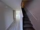 Welcoming staircase leading to the upper level, complemented by neutral walls and tile flooring at 5086 Rain Shadow Dr, St Cloud, FL 34772