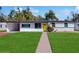 Bright white home with teal accents, yellow door and manicured lawn at 617 S Seneca Blvd, Daytona Beach, FL 32114