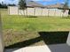 Fenced-in backyard with a grassy area and mature trees at 2243 Tay Wes Dr, Saint Cloud, FL 34771