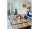 Dining area with a wood table, grey chairs and a view of the kitchen island with barstools at 2243 Tay Wes Dr, Saint Cloud, FL 34771