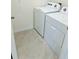 Efficient laundry room with a white washer and dryer set, complete with neutral-toned tile flooring at 2243 Tay Wes Dr, Saint Cloud, FL 34771