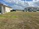 Empty lot with dry grass and a view of nearby houses and a vehicle at 2243 Tay Wes Dr, Saint Cloud, FL 34771