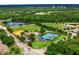 Aerial view of multiple tennis courts, a baseball field, and a pond, surrounded by lush green landscape and mature trees at 9918 Turtle Bay Ct, Orlando, FL 32832