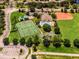 Aerial view of tennis courts, a baseball field, a pool, clubhouse, and a parking lot with mature trees and landscaping at 9918 Turtle Bay Ct, Orlando, FL 32832