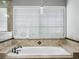 Close up of soaking tub with tile surround and fixtures at 9918 Turtle Bay Ct, Orlando, FL 32832