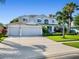 Two-story house with gray siding, three-car garage, and landscaped yard at 9918 Turtle Bay Ct, Orlando, FL 32832