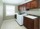 Practical laundry room with washer, dryer, sink, and storage cabinets at 9918 Turtle Bay Ct, Orlando, FL 32832