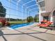 Relaxing screened pool and spa with lounge chairs, overlooking a golf course at 9918 Turtle Bay Ct, Orlando, FL 32832