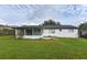 The backyard features a white home with a screened-in patio and a spacious green lawn at 103 Bonita Pl, Ormond Beach, FL 32174