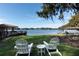 Serene lake view from backyard with two white Adirondack chairs at 1429 Chapman Cir, Winter Park, FL 32789