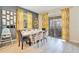 Bright dining room featuring a modern white table, stylish chairs, and sunny yellow patterned curtains at 2736 Bookmark Dr, Kissimmee, FL 34746