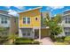 Inviting two-story home with a yellow facade, manicured landscaping, and a paver driveway at 2736 Bookmark Dr, Kissimmee, FL 34746