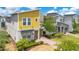Modern two-story home featuring a bright yellow facade, attached garage, and meticulously manicured landscaping at 2736 Bookmark Dr, Kissimmee, FL 34746