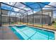 Private pool with a spa, surrounded by a screened enclosure and lush landscaping at 2736 Bookmark Dr, Kissimmee, FL 34746