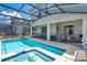 Backyard pool with integrated spa, surrounded by a screened enclosure and patio area at 2736 Bookmark Dr, Kissimmee, FL 34746