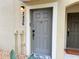 Close-up view of a gray front door with a welcome mat and the house numbers beside it at 2856 Oakwater Dr # 2856, Kissimmee, FL 34747