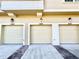 A close-up shot showcases three garages with classic paneled doors, enhancing the townhome's curb appeal at 2856 Oakwater Dr # 2856, Kissimmee, FL 34747