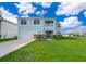 Two-story house with light blue exterior, two-car garage, and well-manicured lawn at 51 Andora Ct, Kissimmee, FL 34758