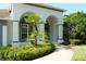 Inviting front entrance with arched entryway, lush landscaping, and a well-maintained walkway at 519 Lakescape Ct, Orlando, FL 32828