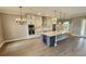 Bright kitchen featuring white cabinets, a stainless steel range hood, island with seating, and modern light fixtures at 0 Sabal St, Orlando, FL 32833