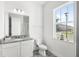 Bright bathroom with granite countertop, white vanity, and a window providing natural light at 10133 Peebles St, Orlando, FL 32827