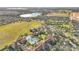 Aerial view of the community clubhouse, pool, and surrounding landscape with a lake at 349 Alcove Dr, Groveland, FL 34736