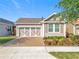 Charming single-Gathering home featuring a decorative garage door, tidy landscaping, and a brick driveway at 349 Alcove Dr, Groveland, FL 34736