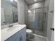 Modern bathroom with a sleek vanity, a toilet, and a glass-enclosed shower at 5069 Rain Shadow Dr, Saint Cloud, FL 34772