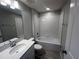 Clean and well-lit bathroom featuring a tub and shower combination with white tile, and a white countertop vanity at 5084 Rain Shadow Dr, Saint Cloud, FL 34772