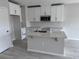 Modern kitchen featuring white cabinets, quartz countertops, and an island at 5084 Rain Shadow Dr, Saint Cloud, FL 34772