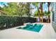 This backyard features a pool with waterfall, meticulous landscaping, and a view of the lush greenery at 7508 Lake Albert Dr, Windermere, FL 34786