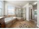Bathroom featuring a soaking tub, walk-in shower, granite counters, and tile floors at 7508 Lake Albert Dr, Windermere, FL 34786