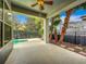 A relaxing covered patio features a ceiling fan and landscaping near the pool, offering a serene outdoor space at 7508 Lake Albert Dr, Windermere, FL 34786
