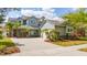 Charming two-story home with lush, tropical landscaping and a brick paved driveway at 7508 Lake Albert Dr, Windermere, FL 34786
