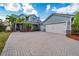 Beautiful two-story home featuring a three-car garage, brick paved driveway and lush landscaping at 7508 Lake Albert Dr, Windermere, FL 34786