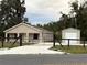 Charming home featuring a gated driveway, metal garage, and a cozy front porch at 9650 Nw Gainesville Rd, Ocala, FL 34475