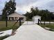 Gated property featuring a home and a detached garage with a long driveway at 9650 Nw Gainesville Rd, Ocala, FL 34475