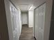 Hallway with wood-look floors and white closet doors offers ample storage space in a home at 9650 Nw Gainesville Rd, Ocala, FL 34475