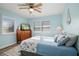 Bright bedroom with a queen bed, dresser, and window shutters at 110 Surf St, New Smyrna Beach, FL 32169