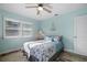 Bedroom with a queen bed, window shutters, and light blue walls at 110 Surf St, New Smyrna Beach, FL 32169