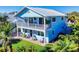 Two-story light blue house with large deck at 110 Surf St, New Smyrna Beach, FL 32169