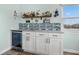 Wet bar with wine cooler, granite countertop, and stylish tile backsplash at 110 Surf St, New Smyrna Beach, FL 32169