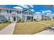 Inviting two-story townhome with a landscaped lawn and covered porch, offering a charming and welcoming exterior at 514 Rainbow Springs Loop, Groveland, FL 34736