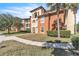 Building exterior featuring Spanish-style architecture, landscaping, and a walkway at 5512 Metrowest Blvd # 110, Orlando, FL 32811